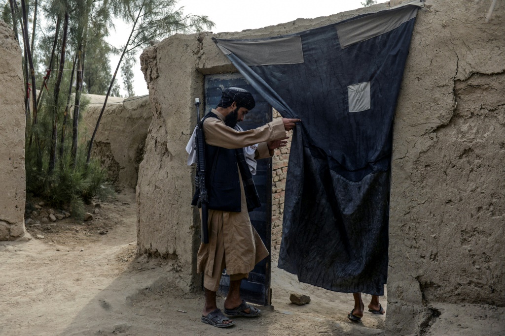 أحد عناصر طالبان يدخل منزل قائد حركة طالبان هبة الله أخوند زادة في مسقط رأسه بقرية سبروان بتاريخ 7 تشرين الثاني/نوفمبر 2021 (ا ف ب)