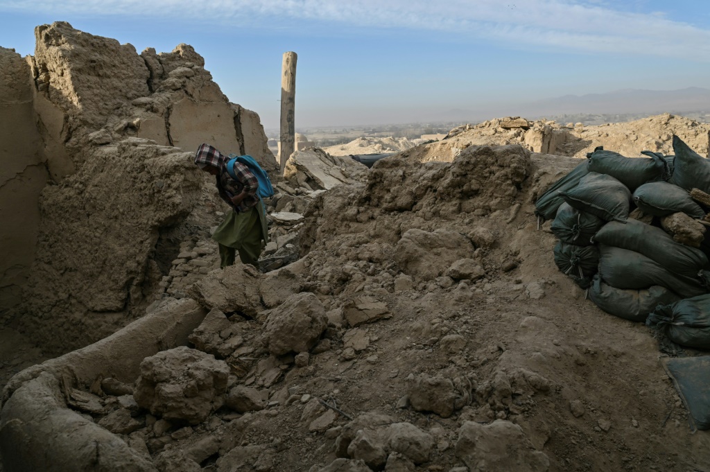فتى يسير قرب منازل مهدومة في قرية آرزو بجنوب أفغانستان في 16 تشرين الثاني/نوفمبر 2021 (ا ف ب)