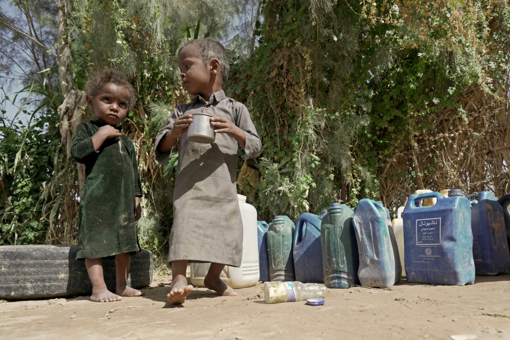    أطفال يشربون الماء في مخيم السميا للنازحين اليمنيين شرق مدينة مأرب في اليمن في 24 من تشرين الثاني/نوفمبر 2021 (أ ف ب)   