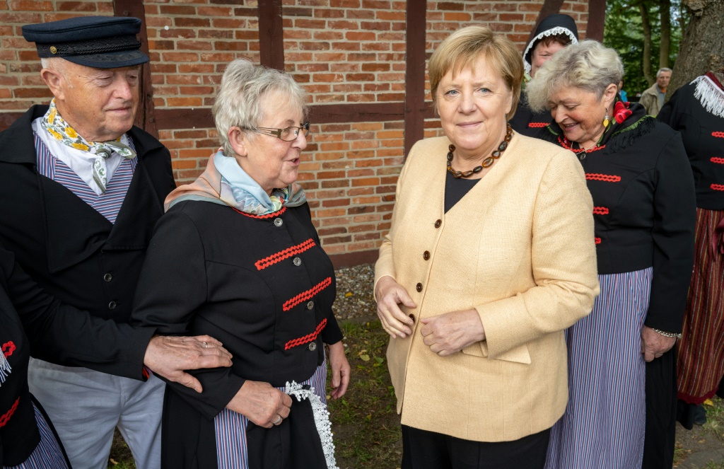 المستشارة الألمانية أنغيلا ميركل تلتقي نساء يرتدين الزي التقليدي خلال زيارة لقرية صيادي السمك 