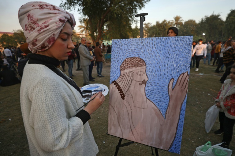 صورة التقطت في 27 تشرين الثاني/نوفمبر 2021 لامرأة ترسم خلال الدورة الثامنة من مهرجان الكتاب في بغداد التي حملت شعار "أنا عراقي ..أنا أقرأ" ( ا ف ب )