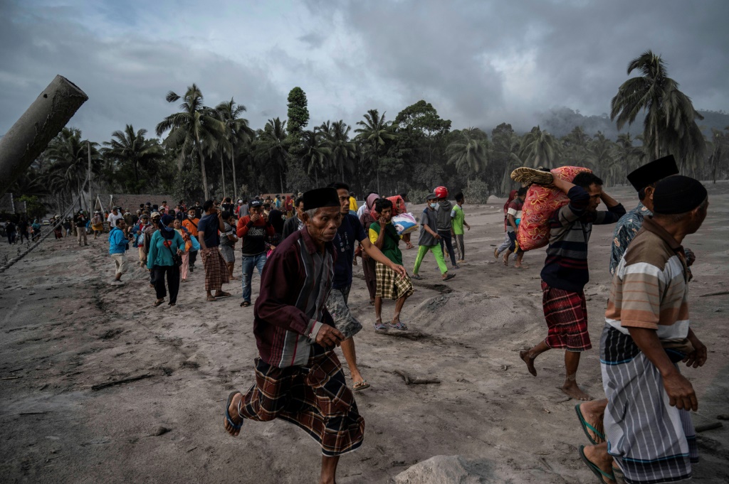 قروين يركضون هجرًا للأماكن التي يسكنونها جرّاء ثوران بركان سيميرو في منطقة لوماجانغ في اندونيسيا في 5 كانون الأول/ديسمبر 2021 (أ ف ب)