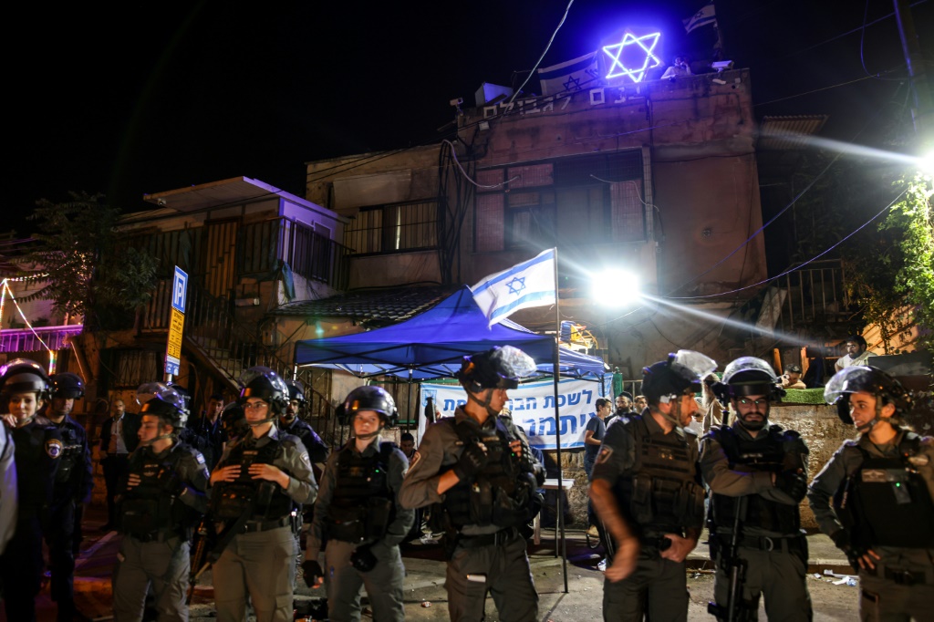 حرس الحدود الإسرائيلي يقف أمام منزل احتله مستوطنون يهود خلال اشتباكات حول حقوق الأرض في مايو (أ ف ب)