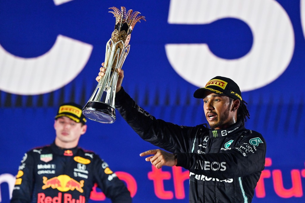 سائق مرسيدس البريطاني هاميلتون يرفع كأس المركز الأول لسباق جائزة السعودية الكبرى (ا ف ب)