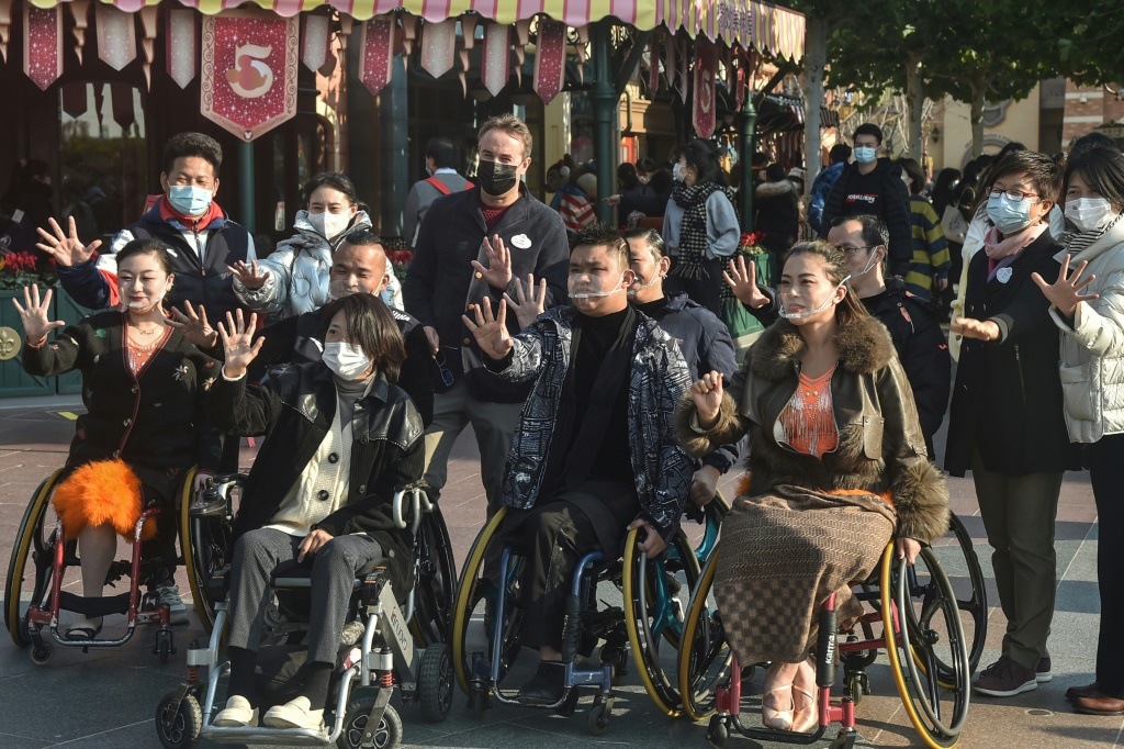 راقصون على كرسي متحرك يلتقطون صورا مع أعضاء في مجمع ديزني لاند في مدينة شنغهاي (ا ف ب)