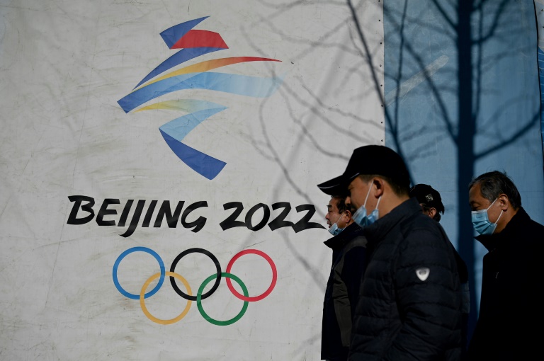  مارة قرب شعار الألعاب الأولمبية الشتوية في متنزه شوغانغ في بكين في 1 كانون الأول/ديسمبر 2021 (ا ف ب).