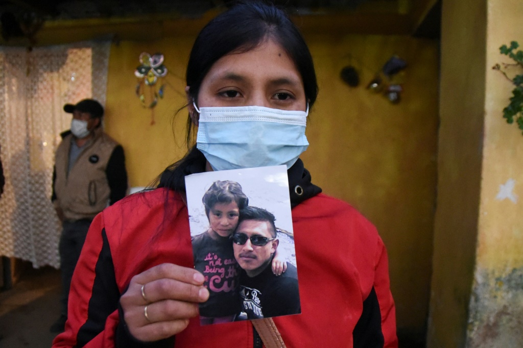 لوكريسيا ألبا خامينيس ترفع صورة لزوجها سيلسو في منزلها في سانتا لوسيا اوتالتان في غواتيمالا في العاشر من كانون الأول/ديسمبر 2021 (ا ف ب)   
