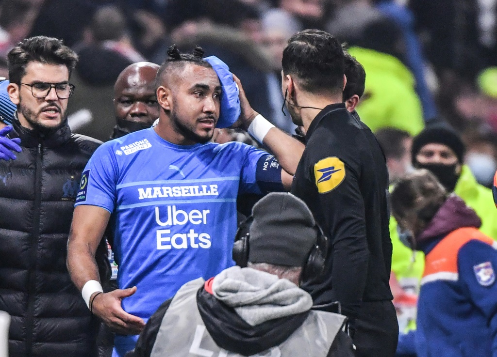 لاعب وسط مرسيليا ديميتري باييت يغادر الملعب بعد اصابته بمقذوفة خلال المباراة ضد ليون (ا ف ب)