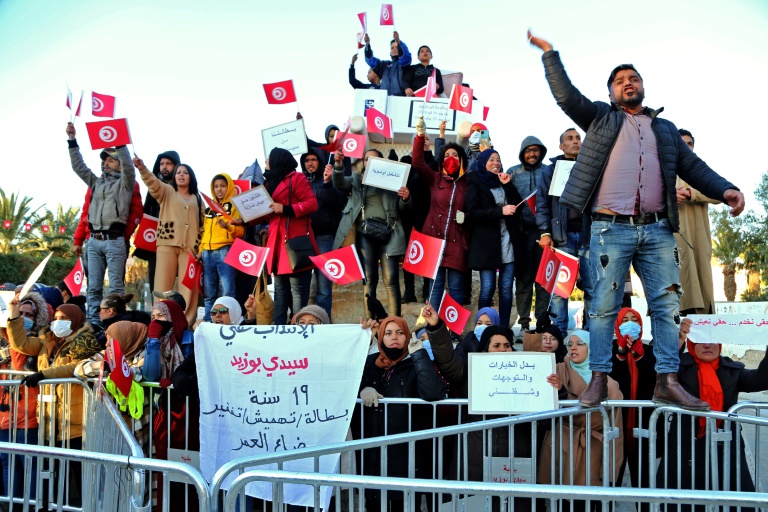  خريجون تونسيون عاطلون عن العمل يرددون شعارات خلال تظاهرة لإحياء الذكرى 11 لانطلاق ثورة 2011، في 17 كانون الأول/ديسمبر 2021، في سيدي بوزيد، معقل الثورة التونسية (اف ب)