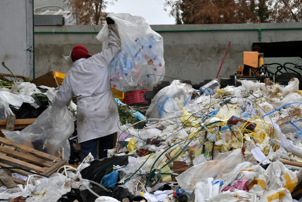 عاملة في مصنع "افريقيا للرسكلة" وسط أكوام من نفايات البلاستيك في المنطقة الصناعية في المغيرة بالقرب من العاصمة التونسية في 25 تشرين الثاني/نوفمبر 2021 (ا ف ب)