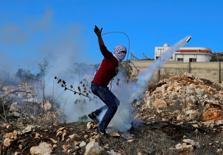 متظاهر فلسطيني خلال مواجهات مع القوى الأمنية الإسرائيلية في بلدة كفرقدوم في الضفة الغربية المحتلة في 10 كانون الول/ديسمبر 2021 (ا ف ب)