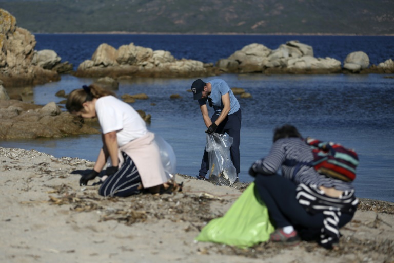 صورة مؤرخة في 20 تشرين الثاني/نوفمبر 2021 لمتطوعين ينظفون أحد شواطئ كورسيكا من البلاستيك(ا ف ب)   