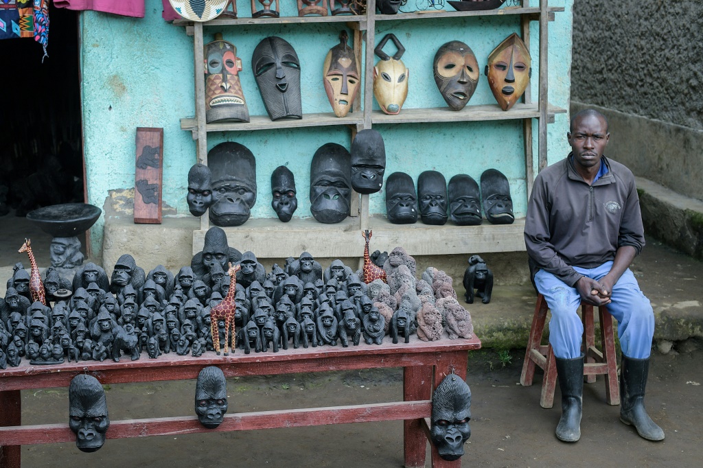 رجل محلي يعرض هدايا تذكارية للبيع عند مدخل حديقة البراكين الوطنية في رواندا (أ ف ب)