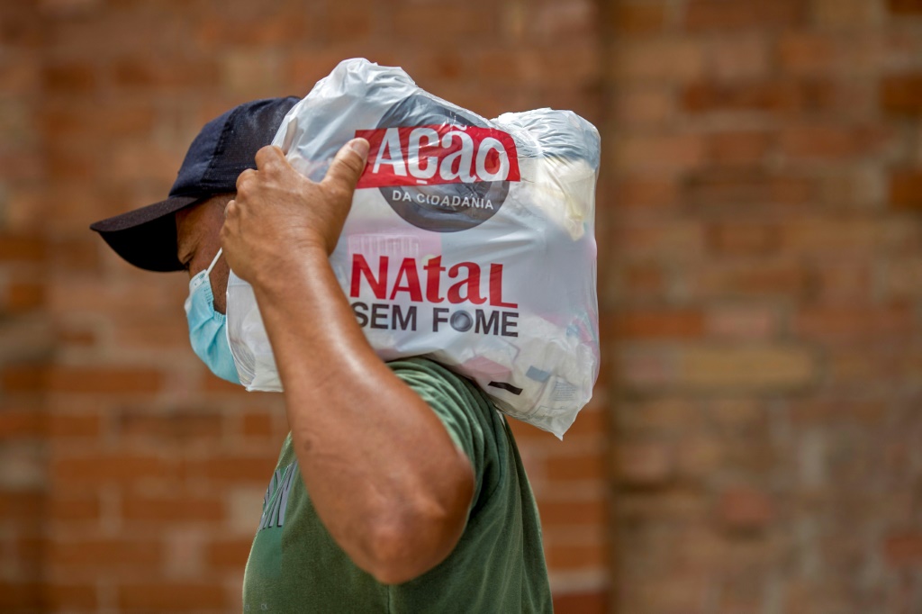 متطوع يحمل حصة من المساعدات الغذائية ضمن حملة "ناتال سيم فومي" الخيرية (ا ف ب)