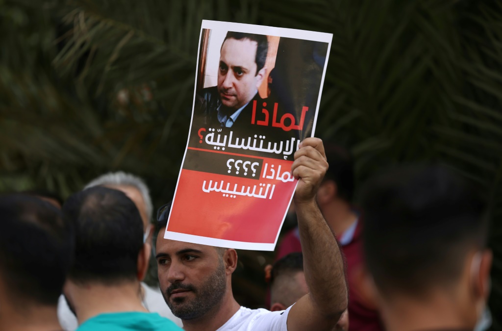 مناصر لحزب الله وأمل يحمل صورة للقاضي طارق بيطار في بيروت في 14 أكتوبر 2021 خلال احتجاج للمطالبة بإقالته (أ ف ب)