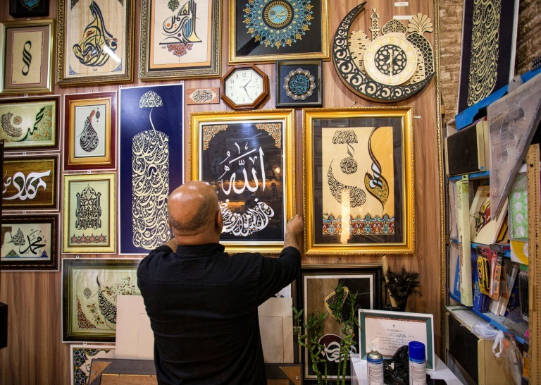 الخطاط العراقي وائل الرمضان في محترفه في منطقة العشار بمدينة البصرة جنوب العراق في 19 كانون الأول/ديسمبر 2021 (ا ف ب)