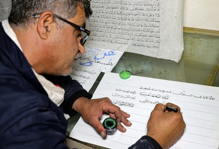 العراقي جمال رسول حسين يتمرن على الخط العربي في منزله بمدينة رانية على بعد 130 كيلومترا شمال السليمانية في كردستان العراق في 17 كانون الأول/ديسمبر 2021 (ا ف ب)