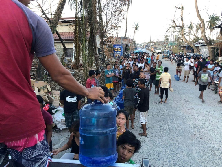 سكان بلدة جنرال لونا في جزيرة سيارغاو يقفون في طوابير للحصول على مياه الشرب في 23 كانون الأول/ديسمبر 2021 (ا ف ب)