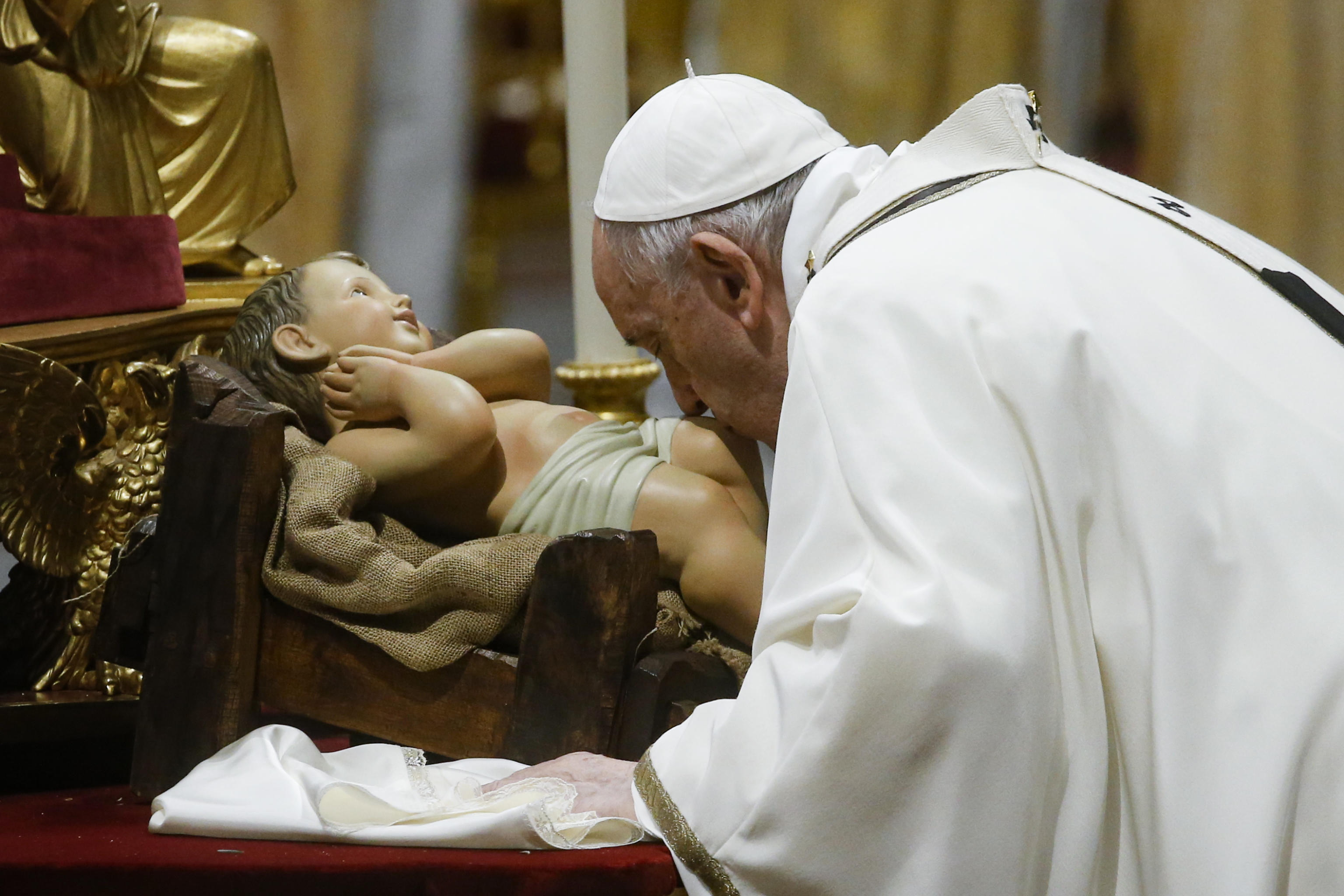  البابا فرنسيس يقبل تمثال يسوع المقدس وهو يقود قداس عيد الميلاد في كنيسة القديس بطرس(د ب أ)