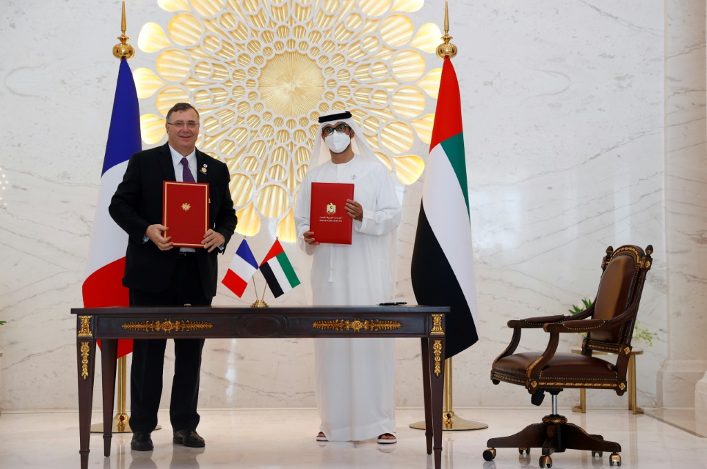 باتريك بويان رئيس شركة توتال إينرجي الفرنسية مع مسؤول إماراتي بعد توقيع اتفاقية ثنائية مع الإمارات العربية المتحدة في دبي في 3 كانون الأول/ديسمبر 2021 (أ ف ب)   