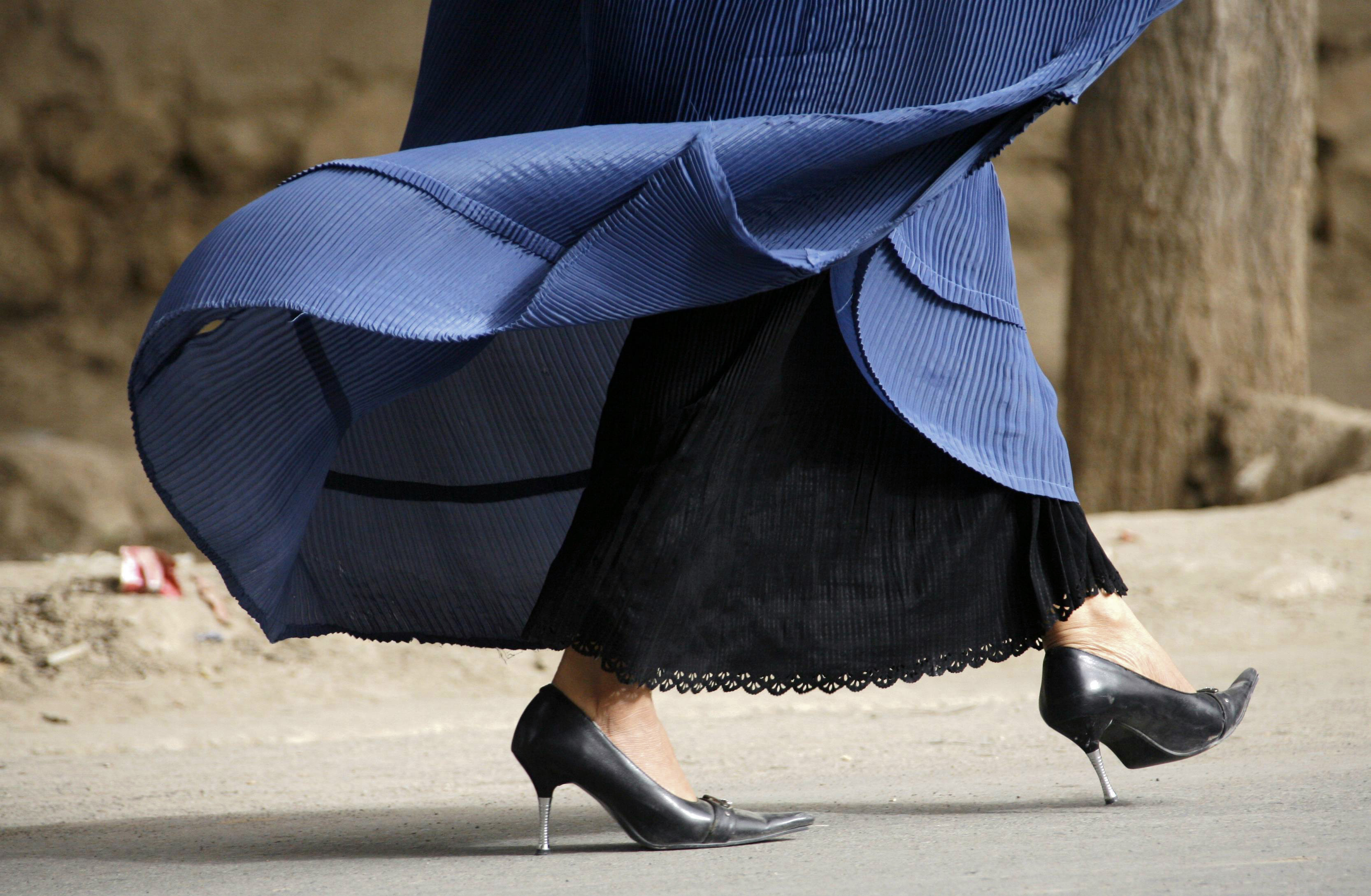  امرأة ترتدي كعبا عاليا وبرقع تسير على طول شارع في تالوكوان(د ب أ)