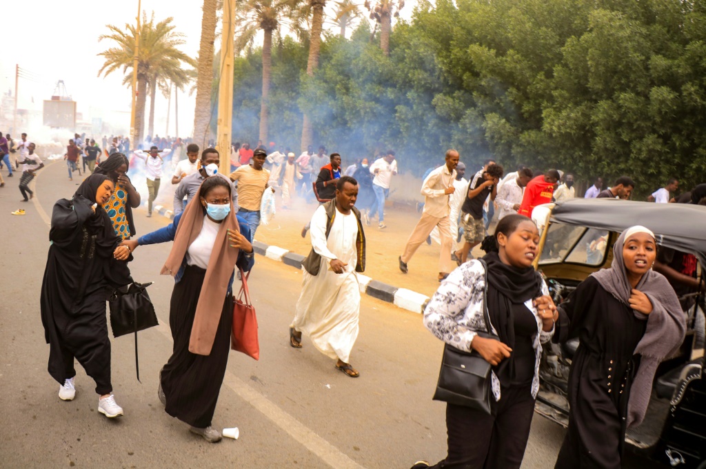 متظاهرون يهربون بعدما أطلقت قوات الأمن قنابل غاز مسيل للدموع لتفريقهم في بورسودان بشرق البلاد في 25 كانون الأول/ديسمبر 2021 (أ ف ب)