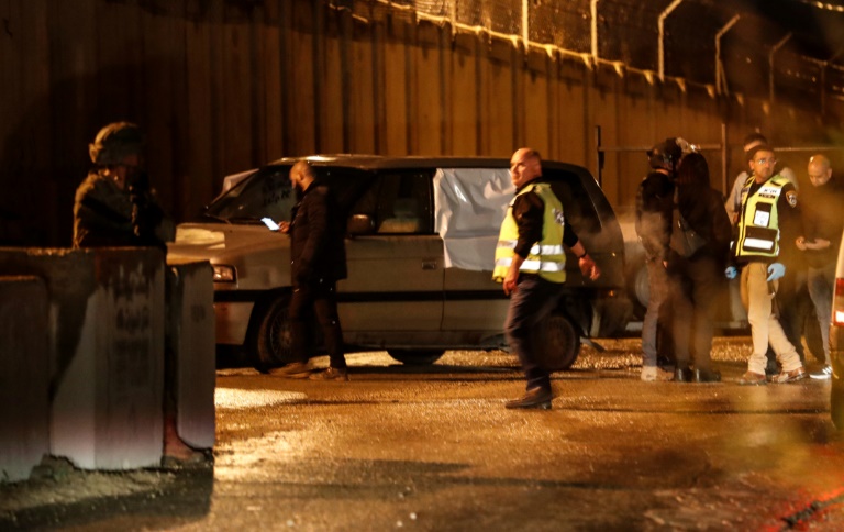 عناصر من القوى الأمنية الإسرائيلية قرب سيارة ثلاثة إسرائيليين تعرضوا لإطلاق نار قرب مستوطنة في الضفة الغربية المحتلة ما أدى إلى سقوط قتيل في 16 كانون الأول/ديسمبر 2021(ا ف ب)