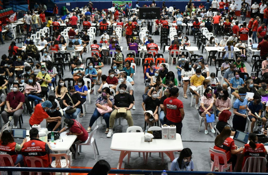 مراهقون ينتظرون لقاح فيروس كورونا في ملعب في مانيلا (أ.ف.ب)