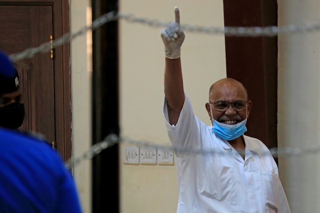 &nbsp;  الرئيس السوداني المخلوع عمر البشير يشير خلال محاكمته على الانقلاب العسكري عام 1989 الذي أوصله إلى السلطة ، في محكمة بالخرطوم في 19 يناير 2021 (أ ف ب)