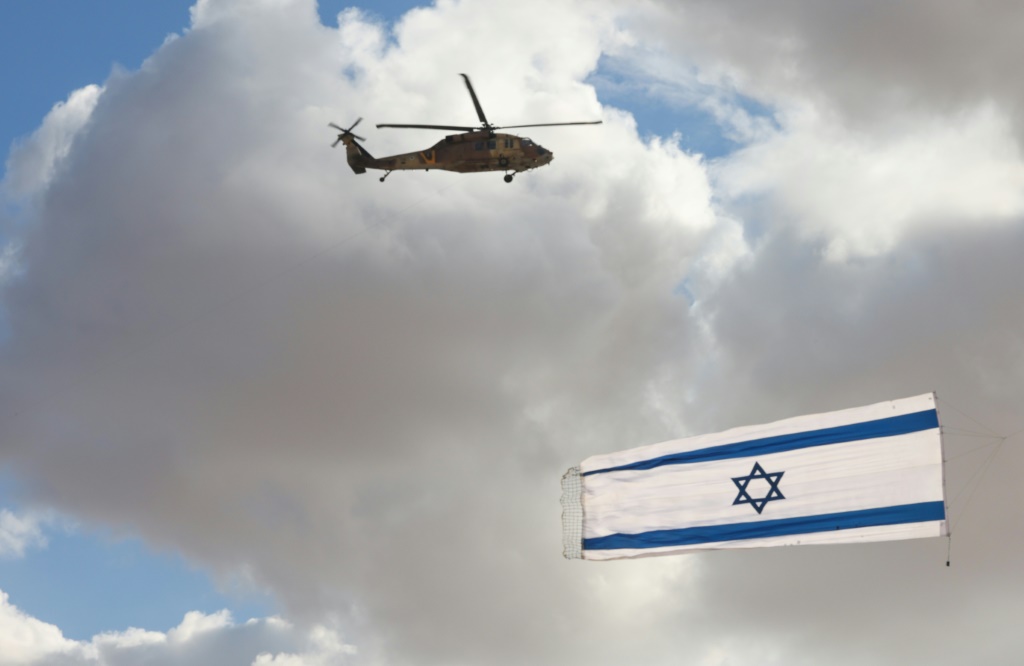 مروحية إسرائيلية من طراز بلاكهوك تحلّق خلال عرض بمناسبة تخريج طيارين في قاعدة هاتزريم الجوية في صحراء النقب في جنوب الدولة العبرية في 22 ك1/ديسمبر 2021.(ا ف ب)