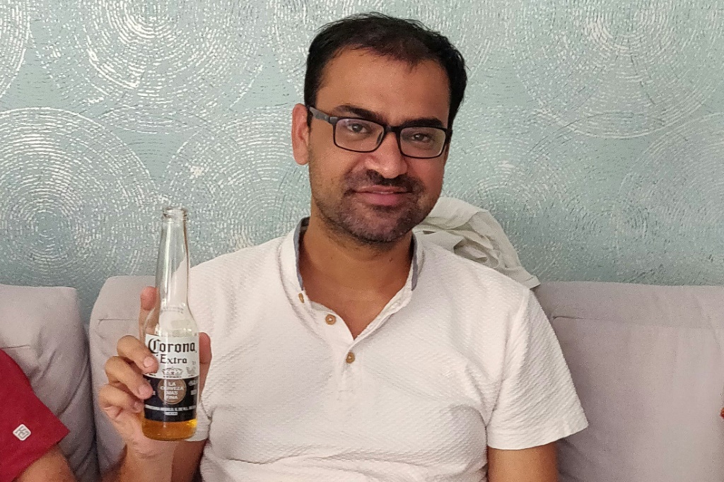 الهندي كوفيد كابور يحمل عبوة مشروب من ماركة "كورونا" في صورة نُشرت في السابع من كانون الثاني/يناير 2022 (أ ف ب)