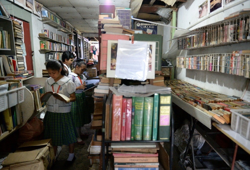 تلاميذ يتصفّحون كتباً في إحدى مكتبات مانيلا في 12 مارس 2014 (ا ف ب)