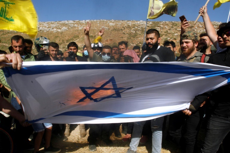أنصار حزب الله يحرقون العلم الإسرائيلي في منطقة الخيام الحدودية في جنوب لبنان بتاريخ 25 أيار/مايو 2021 (ا ف ب)