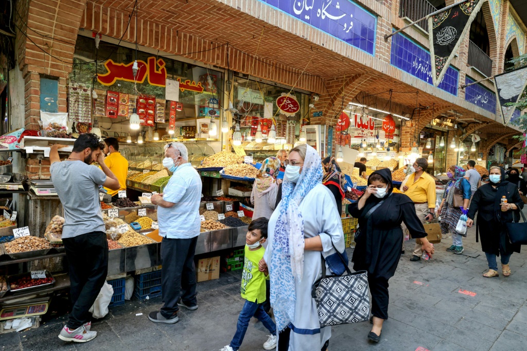 المتسوقون في البازار الكبير بطهران - يخضع الاقتصاد الإيراني لعقوبات أمريكية شديدة ويبلغ معدل التضخم في البلاد حوالي 60٪ (أ ف ب)