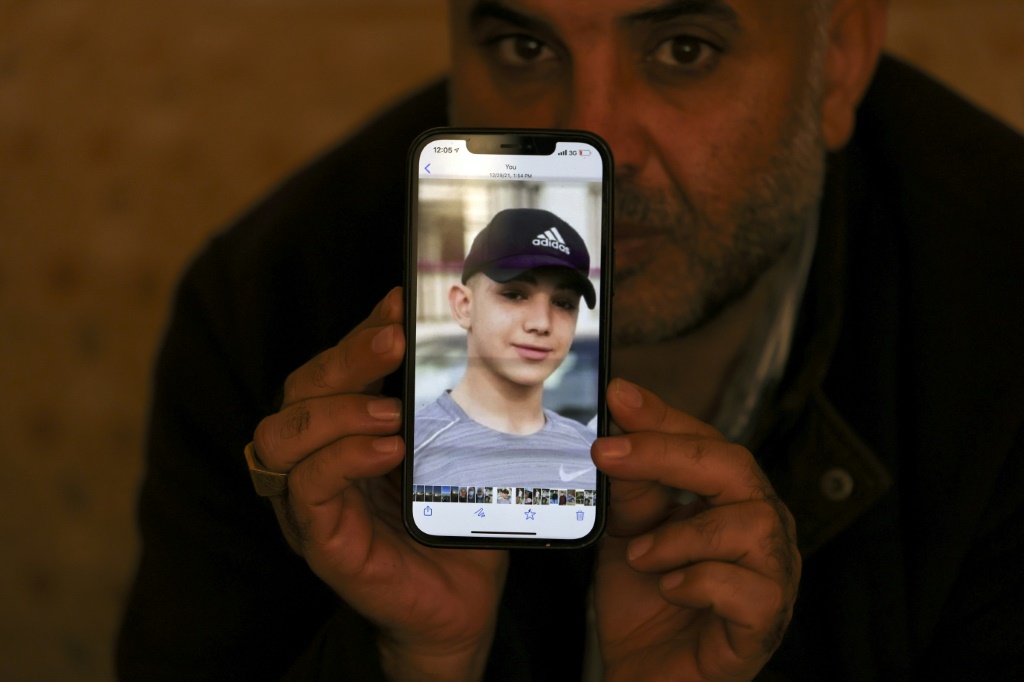 معمر نخلة ، والد الأسيرة الفلسطينية أمل البالغة من العمر 17 عامًا ، يظهر صورة ابنه على هاتفه ، في مخيم الجلزون للاجئين ، بالقرب من مدينة رام الله المحتلة ، في 8 يناير ، 2022 (أ ف ب)