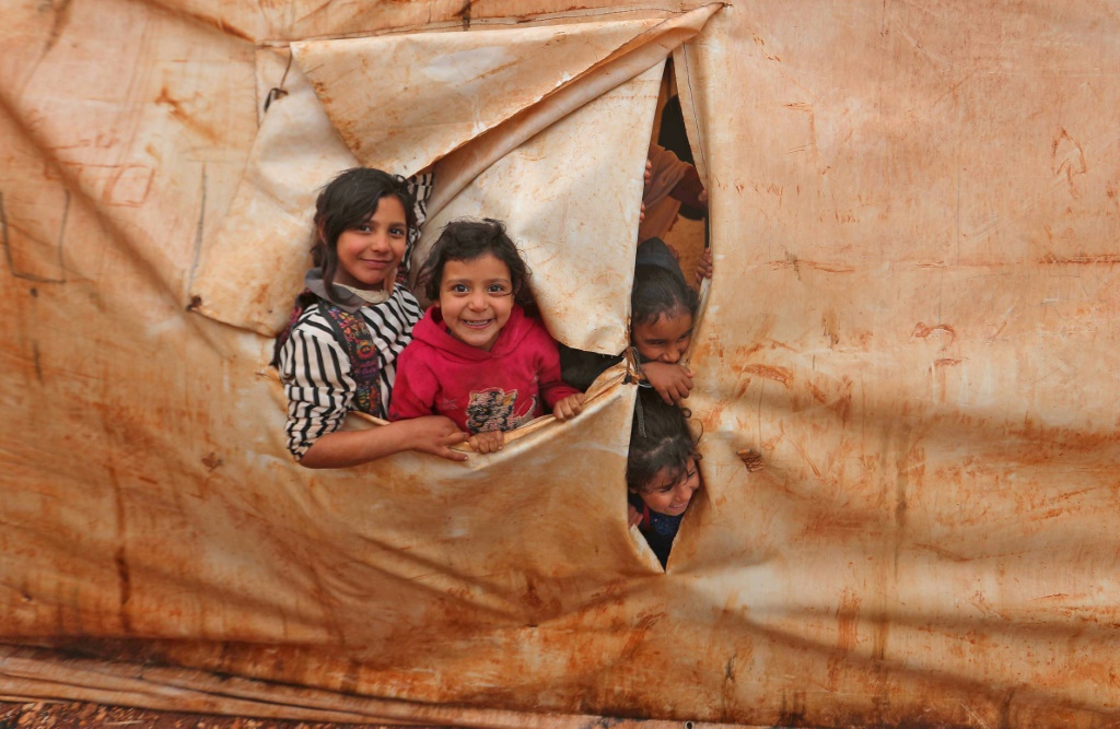 أطفال في أقسام تعليم مؤقتة في مخيم للنازحين بقرية كيلي قرب باب الهوى في محافظة إدلب شمال غرب سوريا بتاريخ 20 كانون الأول/ديسمبر 2021(ا ف ب)