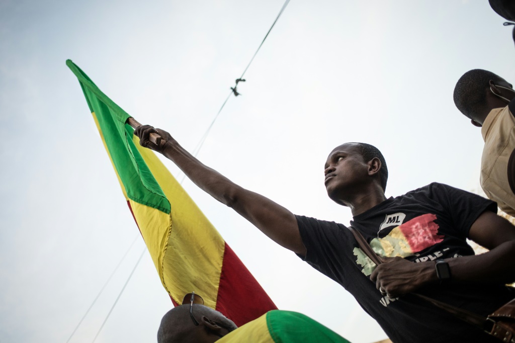 متظاهر يلوح بعلم مالي خلال تظاهرة في باماكو بتاريخ 10 كانون الثاني/يناير احتجاجا على عقوبات المجموعة الاقتصادية لدول غرب إفريقيا(ا ف ب)