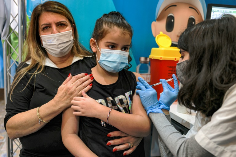 ممرضة إسرائيلية تحقن طفلة (8 سنوات) بجرعة من لقاح فايزر المضاد لفيروس كورونا في إحدى العيادات الصحية التابعة لصندوق المرضى(د ب أ)