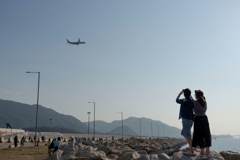 شخصان يلتقطان الصور قرب مطار هونغ كونغ في 14 تشرين الثاني/نوفمبر 2021(ا ف ب)