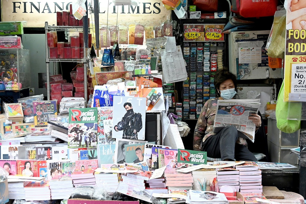 بائعة جرائد تقرأ صحيفة في هونغ كونغ في 6 كانون الثاني/يناير 2022(ا ف ب)