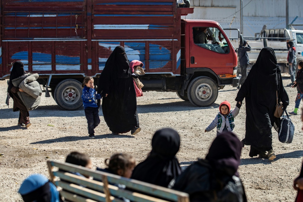 نساء وأطفال خلال إعادة قسم من المتواجدين في مخيم الهول إلى ديارهم في 20 شباط/فبراير 2021 (ا ف ب)