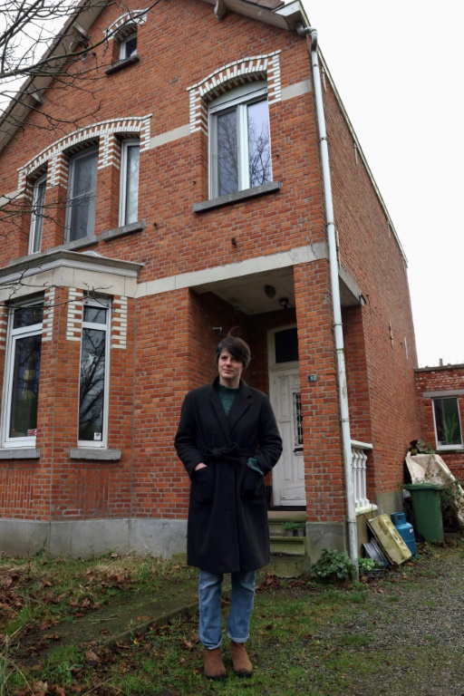 ليزي ستوير إحدى المقيمين القلائل في قرية دويل قرب أنتويرب في بلجيكا، أمام منزلها في السابع من يناير 2022 (ا ف ب)