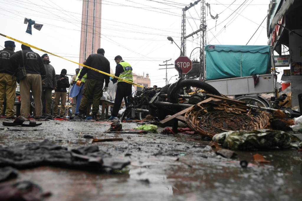 مسؤولون أمنيون يتفقدون موقع انفجار عبوة ناسفة أسفر عن مقتل شخصين وإصابة 22 آخرين في لاهور (أ ف ب)