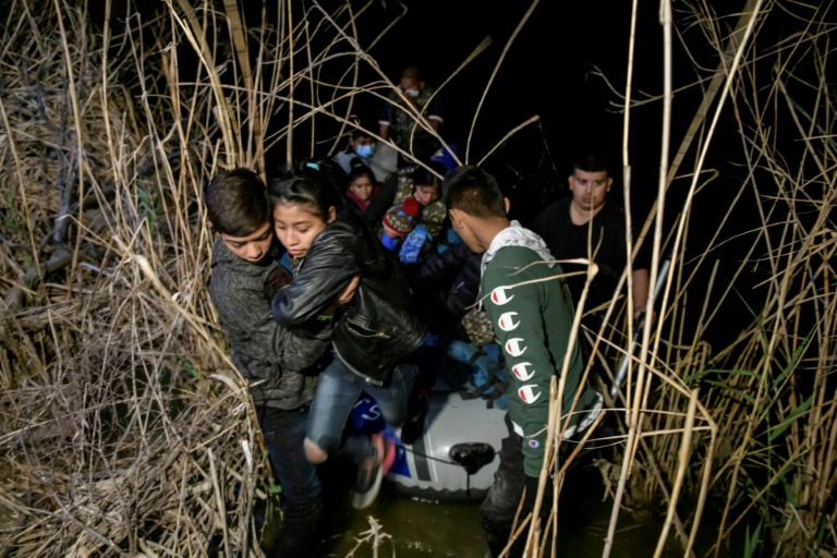  مهاجرون من هندوراس وغواتيمالا ينزلون من مركب مهربين بعد عبور نهر ريو غراند في روما بولاية تكساس الأميركية في 28 آذار/مارس 2021(ا ف ب)