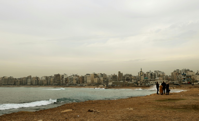 لبنانيون يسيرون قرب شاطىء المينا في طرابلس في 13 كانون الأول/ديسمبر 2021  (ا ف ب)