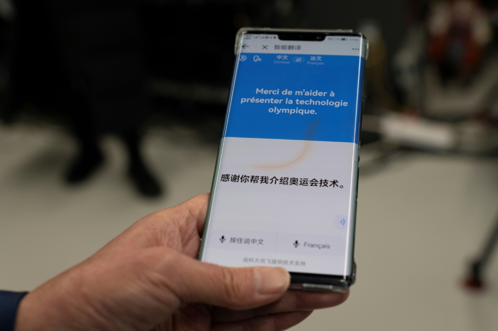 قدّم يو هونغ من اللجنة المنظمة للألعاب الشتوية في بكين 2022 تطبيقًا مخصصًا للألعاب "أم واي 2022" في شوغانغ بارك في 20 يناير 2022 (ا ف ب)