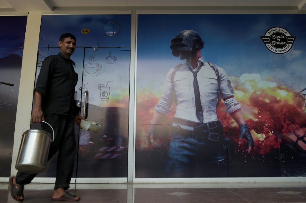 رجل يمر بجانب ملصق للعبة PlayerUnknown's Battlegrounds في مقهى إنترنت في روالبندي (أ ف ب)