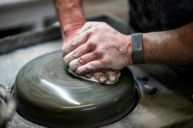 مشرف على الإنتاج جو براون يضع لمساته الأخيرة على حجراً يُصنع في "كايس كيرلينغ" في جنوب غلاسكو في 26 كانون الثاني/يناير 2022 (ا ف ب)