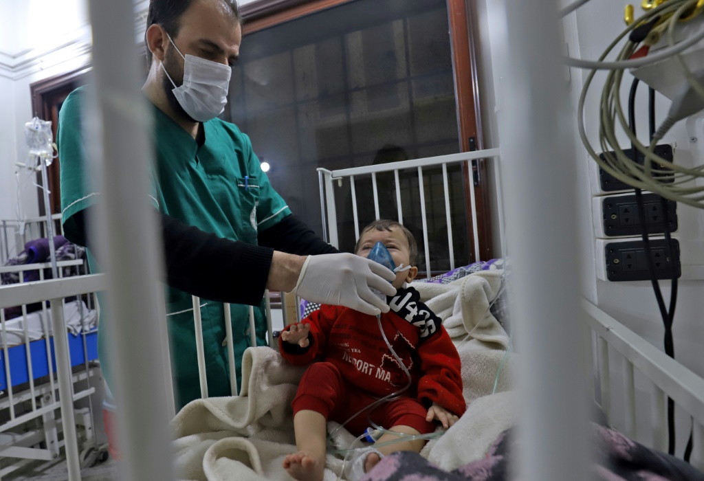 ممرض يثبت قناع الأوكسيجين على وجه طفل يتلقى الرعاية داخل أحد مستشفيات مدينة إدلب في شمال غرب سوريا في 1 شباط/فبراير 2022 (أ ف ب)