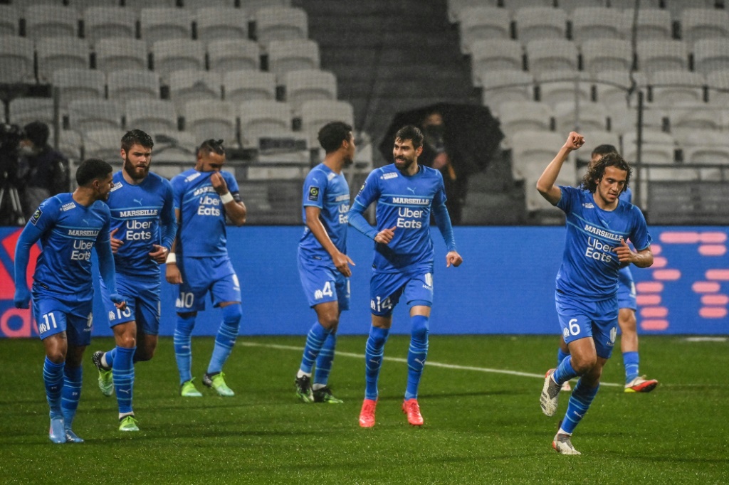 لاعبو مرسيليا يحتفلون بهدف ماتيو غندوزي (إلى اليمين) في مرمى ليون في مباراة مؤجلة من المرحلة 14 في الدوري الفرنسي على ملعب غروباما في الاول من شباط/فبراير 2022(ا ف ب)